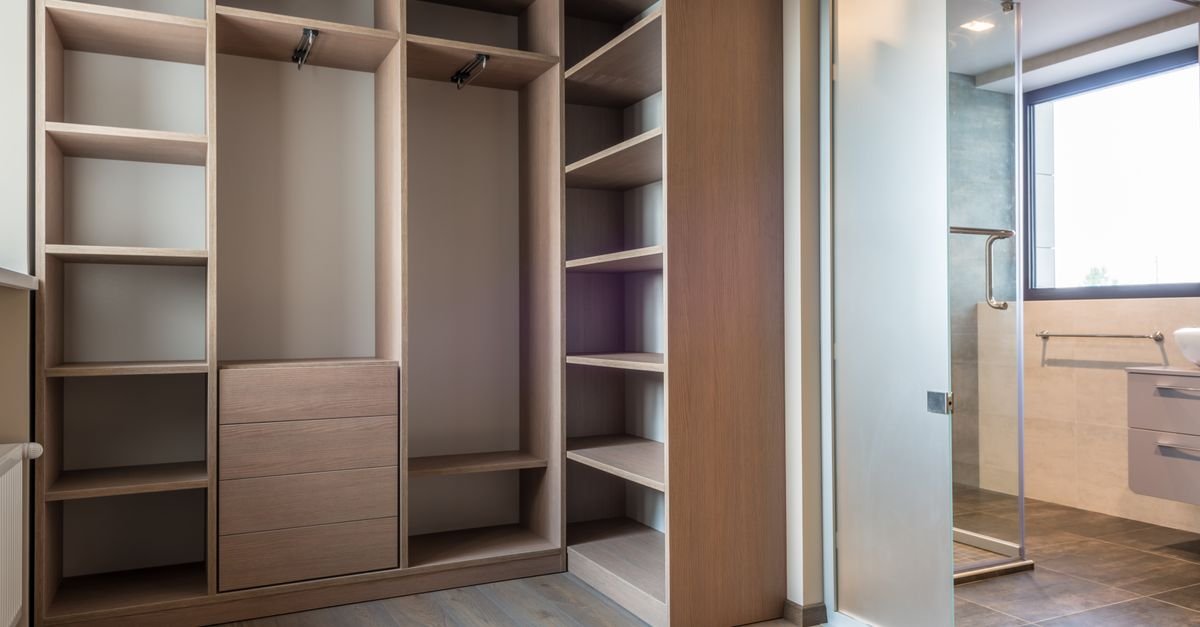 Empty organized walk-in closet with wooden shelves