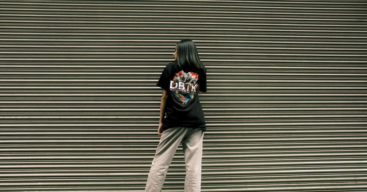 Young woman wearing a Y2K graphic baby tee with baggy jeans and chunky sneakers