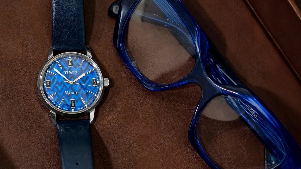 Blue chevron dial Timex Marlin watch with blue eyeglasses on brown leather surface