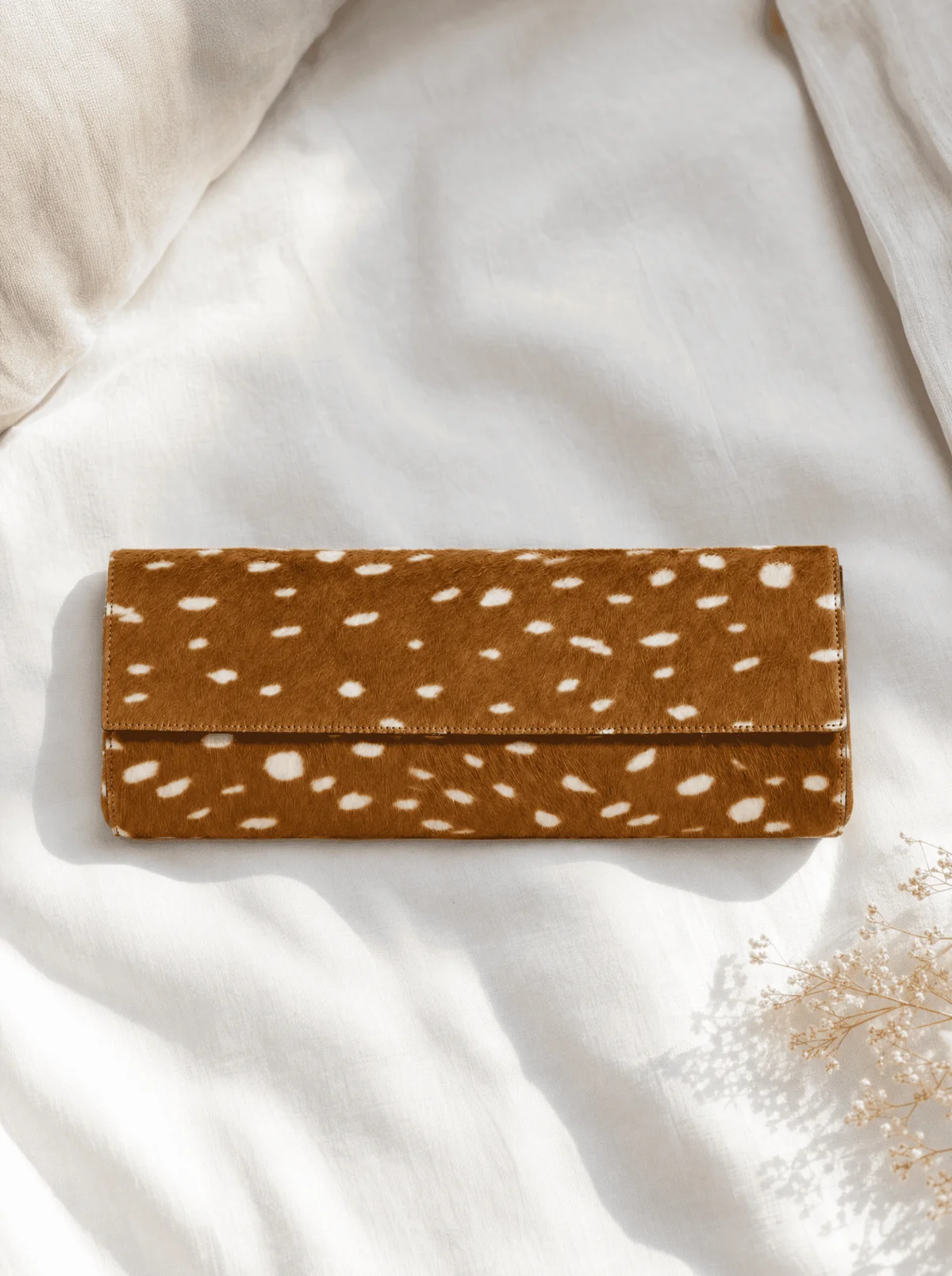Deer print wallet flat lay on rumpled white fabric