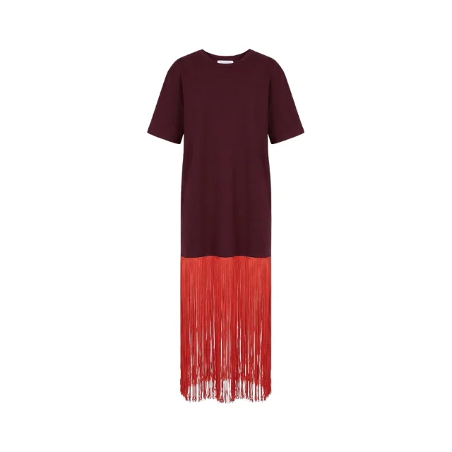 Fringe hem detail of burgundy shirt dress with coral-red fringe strands